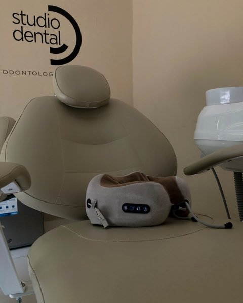 Interior del consultorio Studio Dental: la unidad dental y el logotipo en la pared